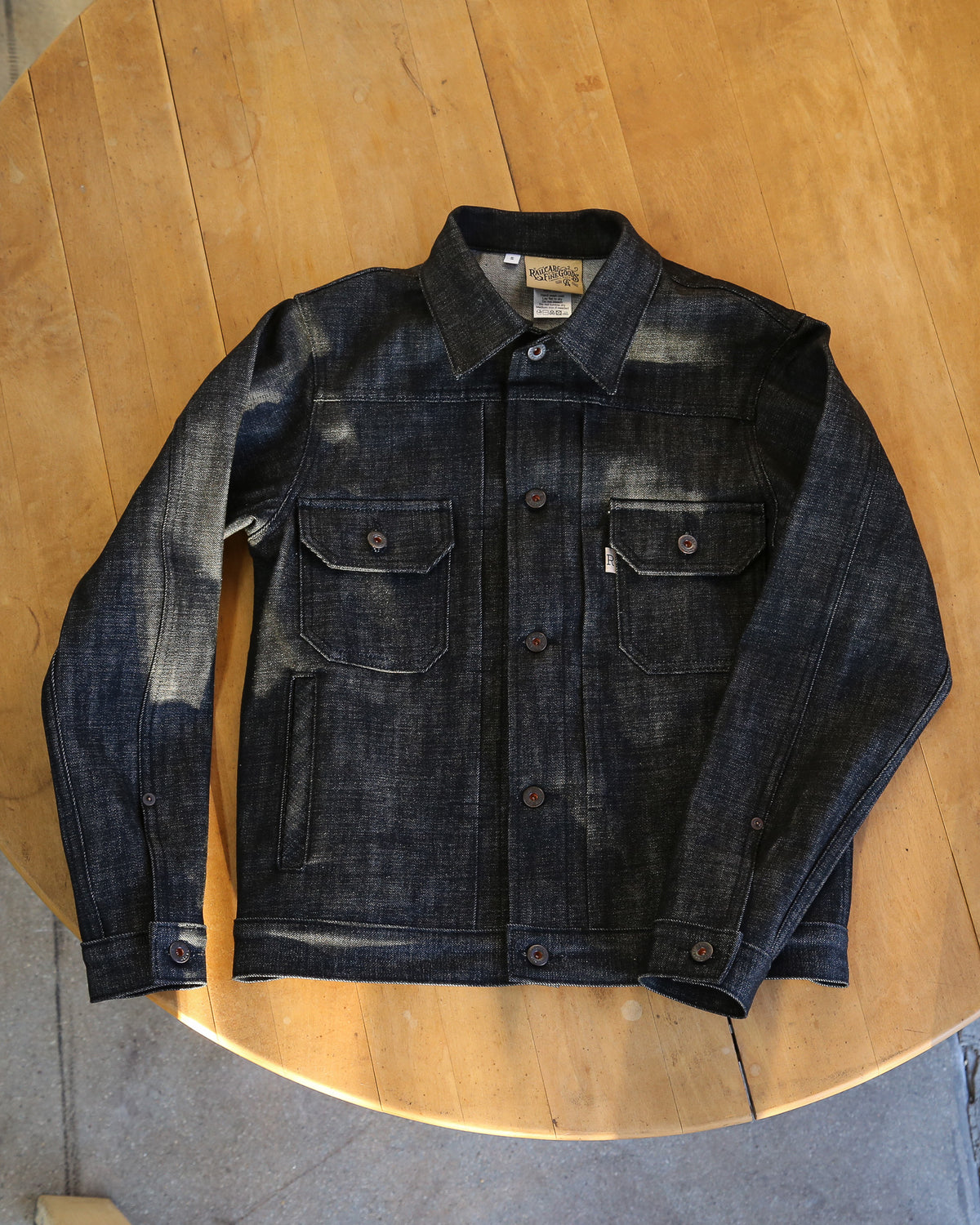 Dark denim jacket on a wooden surface