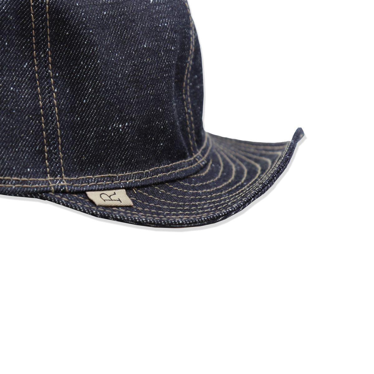 Bill detail of A dark blue nep denim mechanic hat with visible stitching.